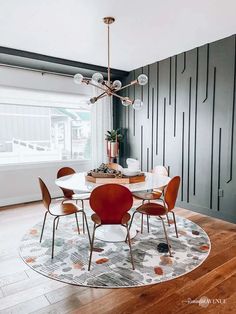 a dining room table with chairs and a chandelier hanging from the ceiling above it