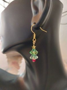 Crystal Lily Shaped bead Christmas Tree Earrings that come in two variations, silver and gold toned stars. ⚬ Free shipping on all orders $35 or above ⚬ Each piece is handmade ⚬ Made in the USA. ⚬ More in our shop: https://www.etsy.com/shop/BellaLilahJewelry QUESTIONS? Please feel free to message me anytime! I'd love to hear it and I'm ready to answer all of your questions! Thank you for visiting Bella Lilah. Handmade Gold Christmas Earrings, Nickel-free Festive Jewelry, Holiday Gold Beaded Jewelry, Handmade Gold Earrings For Christmas, Handmade Jewelry For Holiday Celebration, Handmade Holiday Jewelry For Celebration, Beaded Dangle Christmas Jewelry, Green Dangle Christmas Jewelry, Christmas Beaded Dangle Jewelry