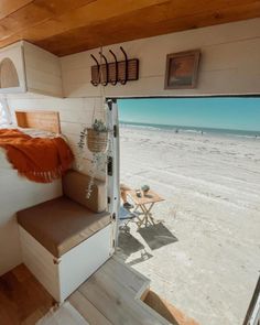 the interior of a mobile home with stairs leading up to the bed area and beach view