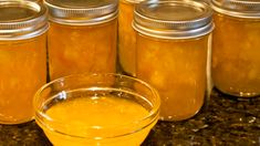 several jars filled with yellow liquid sitting on top of a counter