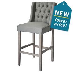 a gray bar stool with a new lower price sign on the back and upholstered seat