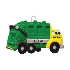 a green and yellow plastic garbage truck ornament with the words year on it