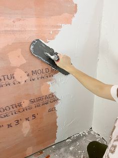 a person with a paint roller painting a wall