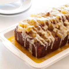 a loaf of bread covered in icing sitting on top of a white plate