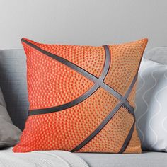 an orange and black basketball pillow on a couch