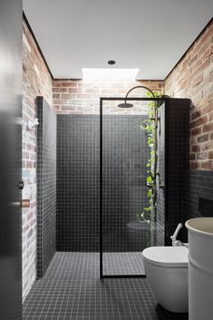 a black and white bathroom with brick walls