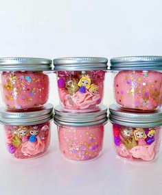 there are four jars with princess decorations in them