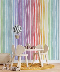 a child's room with rainbow striped wallpaper and wooden toys on the floor