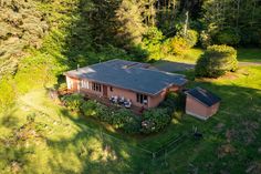 an aerial view of a house in the middle of a wooded area with lots of trees