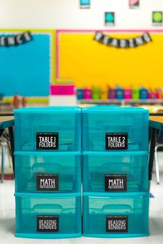 three blue plastic containers with labels on them sitting in front of desks and chairs