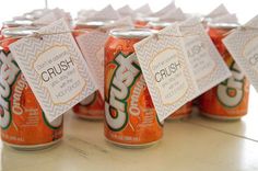 a group of orange sodas sitting on top of a table with price tags attached to them