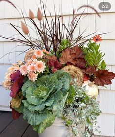 a white pot filled with lots of different types of flowers