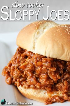 a sloppy joe sandwich sitting on top of a white plate with the words slow cooker sloppy joes