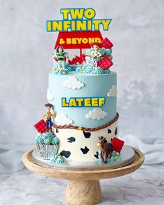 a two tiered cake with toy figures on top and the words two infinitity above it