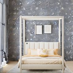 a white bed sitting next to a window in a room with wallpaper on the walls