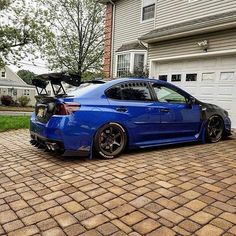 a blue car parked in front of a house