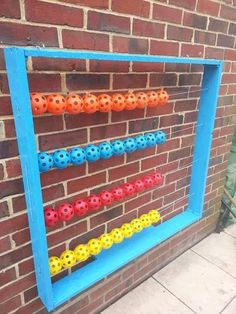 a brick wall with a blue frame holding an abacus