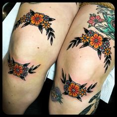 two women with tattoos on their legs, one has flowers and the other has leaves