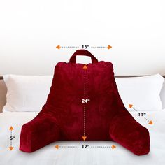 a large red pillow sitting on top of a bed with measurements for the size and width