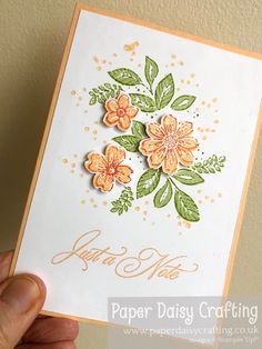 a hand holding up a card with flowers on it and the words paper daisy crafting