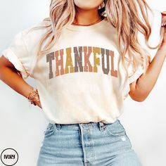 This Comfort Colors® THANKFUL shirt is the perfect tee to throw on all fall.  The autumn colors and classic varsity design stand out amongst the rest.  This t-shirt is sure to be staple in your closet for years to come.  Buy for yourself to wear this Thanksgiving or make this a gift for the person in your life who are are the most grateful for. PLEASE READ THROUGH ALL OF THE FOLLOWING INFORMATION.  IF YOU HAVE FURTHER QUESTIONS, WE ARE HAPPY TO HELP! Welcome to CuratedClothCo.!  Here you can find the perfect, trendy attire whether you are gifting for someone else or yourself.  We strive to provide quality merchandise and quick customer service in order to make your buying process fun and easy.  We hope you love our designs as much as we do! FREE SHIPPING ON ALL ORDERS SHIPPED WITHIN THE U. Varsity Design, Thankful Shirt, Design Stand, Fall Tee, Thanksgiving Shirt, Thanksgiving Outfit, Thanksgiving Shirts, Autumn Colors, Christmas Delivery