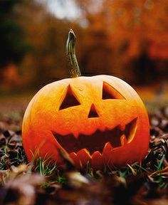 a carved pumpkin sitting in the grass