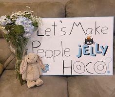 a teddy bear sitting next to a sign that says let's make people jelly hoo