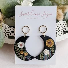 a pair of earrings with flowers on them are sitting next to a card that says sweet connie fyse