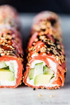 two sushi rolls with cucumber and sesame seeds