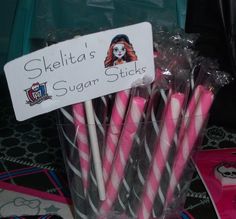 there are many pink and black striped straws in a cup with a sign that says sheila's sugar sticks