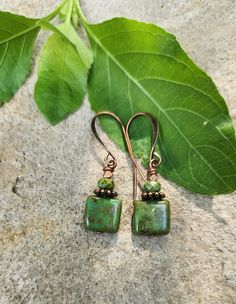 These squares look like green turquoise! Simply gorgeous! Petite Boho earrings featuring square Czech glass beads, accented with matching stack of copper and Czech glass Rondelle beads.  To finish off the look, I added copper hooks.  These beauties are 1 1/2 inches in length, including the hooks.  The square Czech glass bead is just under 1/2 inch wide.   The perfect birthday gift, anniversary surprise, or for yourself "just because."    Versatile. Lightweight. Handmade. Unique design. Smoke fre Adjustable Square Turquoise Jewelry, Green Rectangular Earrings, Green Bohemian Rectangular Earrings, Green Rectangular Bohemian Earrings, Handmade Square Green Jewelry, Square Green Handmade Earrings, Green Rectangular Earrings As A Gift, Rectangular Green Earrings Gift, Handmade Green Square Earrings