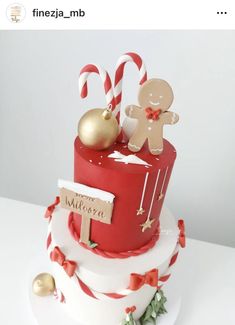 a red and white christmas cake decorated with gingerbreads, candy canes and decorations