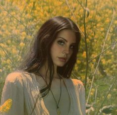 a woman standing in a field with yellow flowers