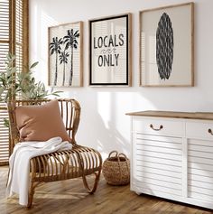 a white room with three pictures on the wall and a wicker chair next to it