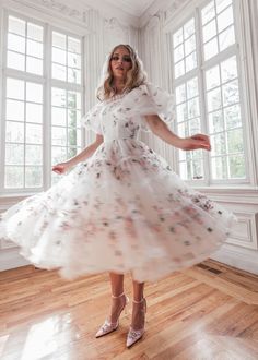 a woman in a white dress is posing for the camera