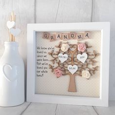 a white frame holding a wooden cutout with the words grandma and two hearts on it