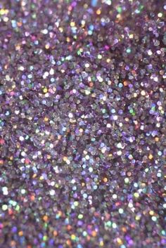 purple glitter with multicolored dots is shown in this close up image, it looks like the surface of a sheet of paper