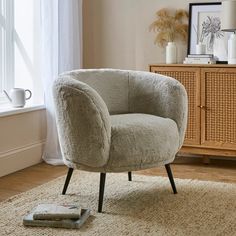 a chair sitting on top of a rug next to a window