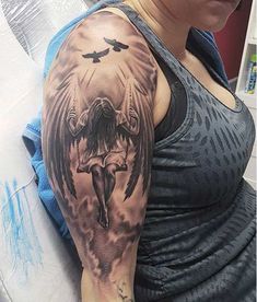 a woman with a tattoo on her arm and an angel above her head holding a cross