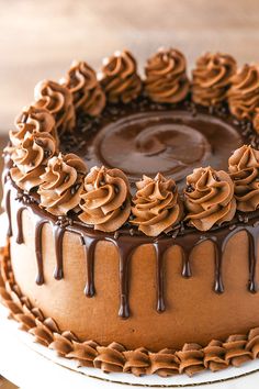 a chocolate cake covered in frosting on top of a white plate with brown icing