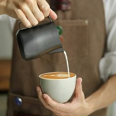 a person pouring coffee into a cup