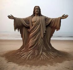 a sand sculpture of jesus on the beach