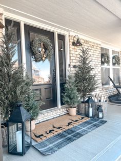 front porch decorated for christmas with evergreen trees and lanterns