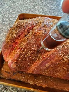 someone is using a syring to check the meat on top of a roasting pan