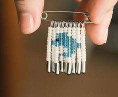 a person is holding a piece of beaded material