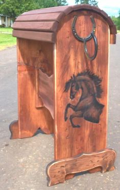 a wooden box with a horse drawn on it's side and a horseshoe hanging from the top