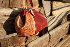 a red purse hanging from the side of a wooden wall