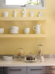 the kitchen counter is lined with dishes and cups