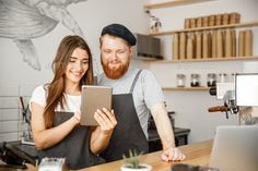 a man and woman are working on an ipad in a coffee shop - stock photo - images