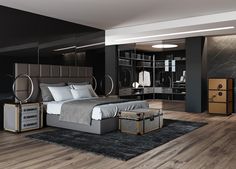 a modern bedroom with black walls and wood flooring, large bed surrounded by mirrored closets